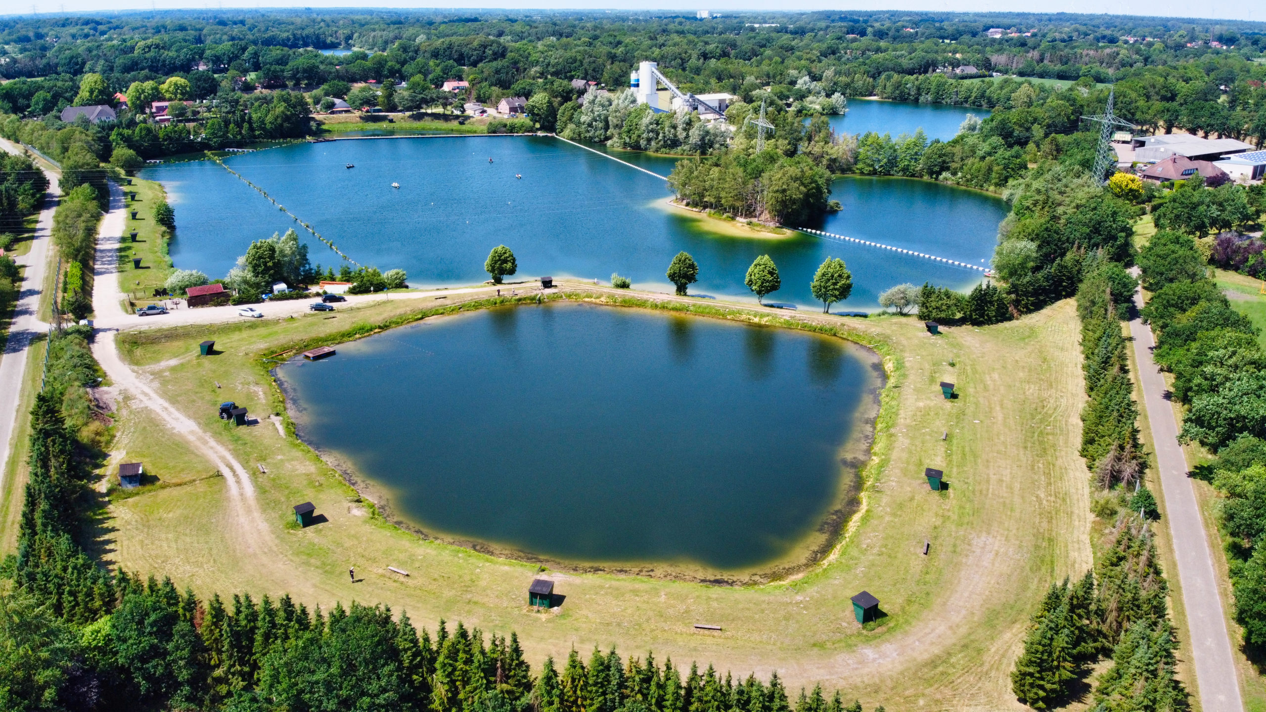 Luftaufnahme der Angelteiche mit baumbestandenen Ufern am Almsee